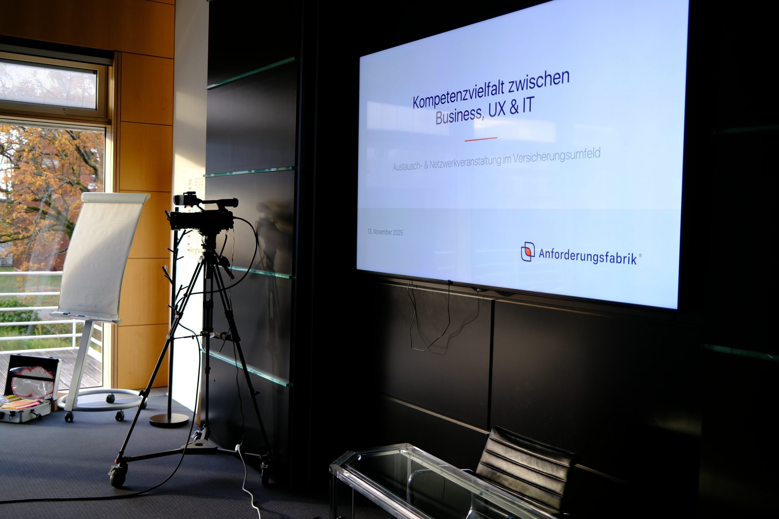 Ein Konferenzraum bei der AXA: Ein großer Display zeigt die Eingangsfolie unserer Präsentation zur Netzwerkveranstaltung