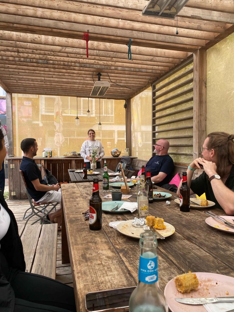 Black Foot Beach Sommerfest: Wir sitzen als Team bei einem entspannten Essen zusammen am Tisch